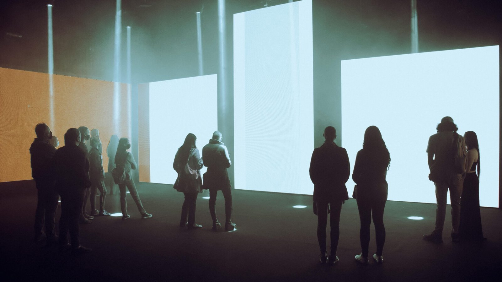 Visitors exploring an immersive digital art exhibition with large illuminated screens.