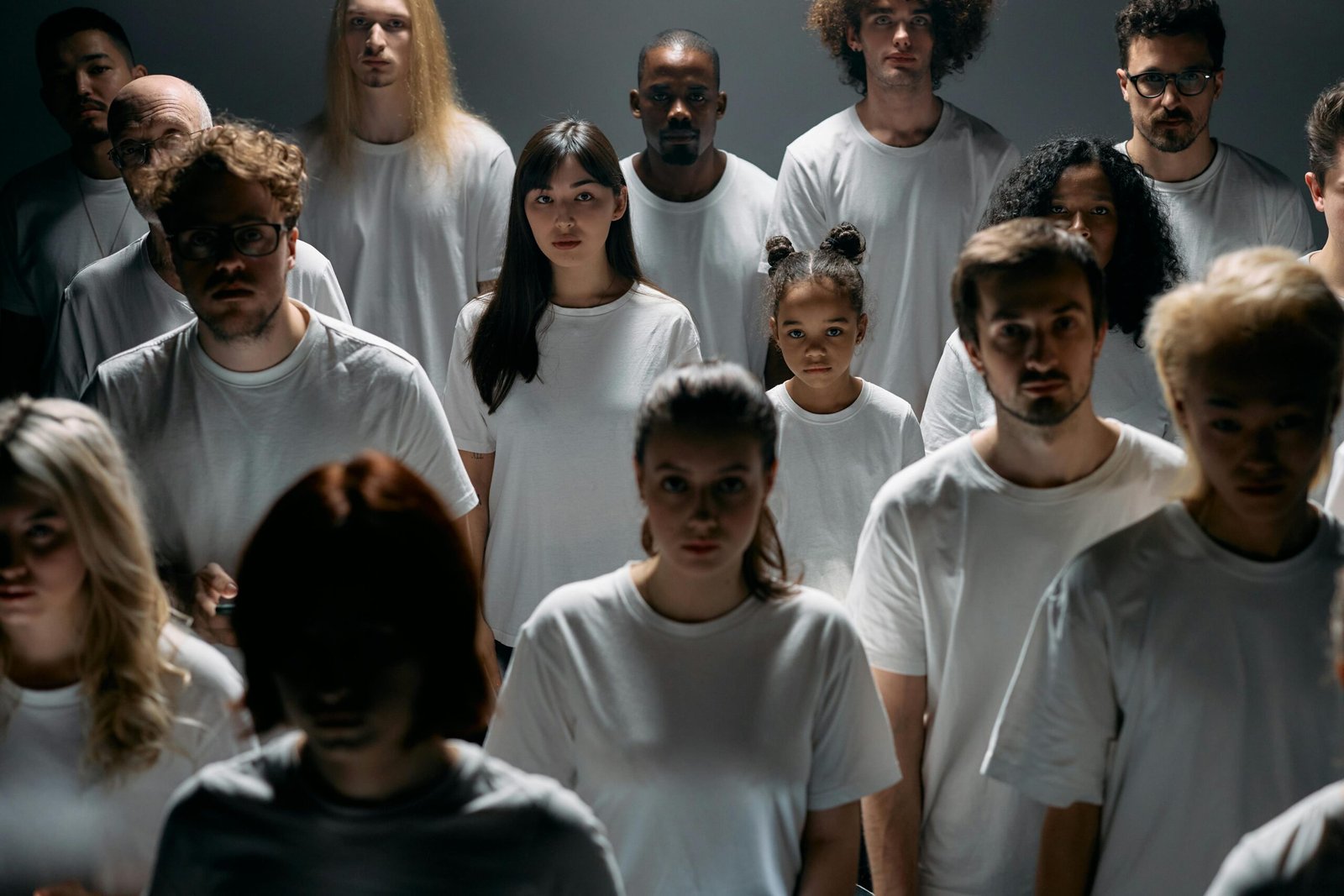 A diverse group of people standing together, emphasizing individuality and unity in a minimalist setting.